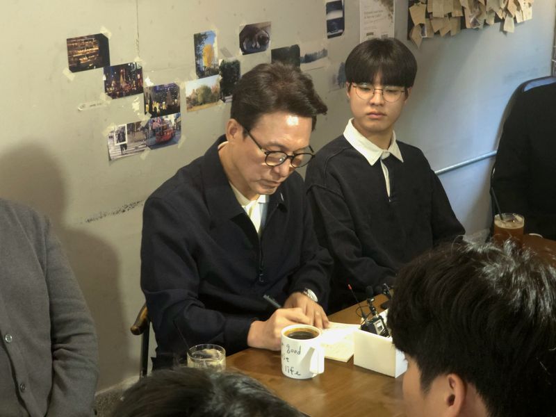 김민석 더불어민주당 대표가 3일 부산 부산진구의 한 카페에서 가진 청년 간담회에서 참석자의 발언을 메모하고 있다. 2026.10.3 ⓒ 뉴스1 이주현 기자