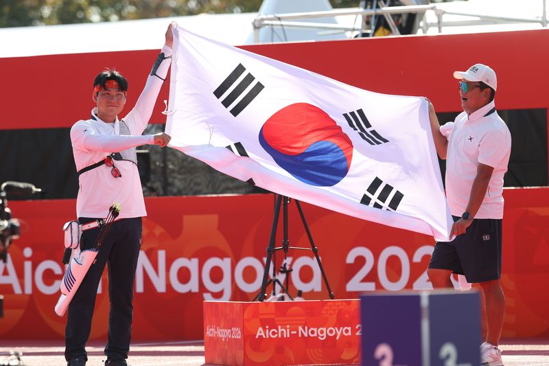 대한민국 이우석이 3일 일본 오카자키 중앙종합공원 다목적광장에서 열린 2026 아이치·나고야 아시안게임 양궁 리커브 남자 개인전 결승에서 일본 나카니시 준야를 꺾고 금메달을 확정지은 후 태극기를 펼쳐보이고 있다. 뉴스1
