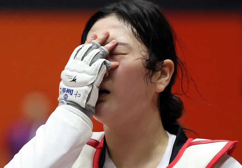 3일 일본 아이치현 도요하시 종합체육관에서 열린 2026 아이치·나고야 아시안게임 태권도 겨루기 여자 67㎏급 한국 송다빈과 중국 무원저 결승 경기. 금메달을 획득한 한국 송다빈이 손으로 얼굴은 가린 상태로 이동하고 있다. 연합뉴스