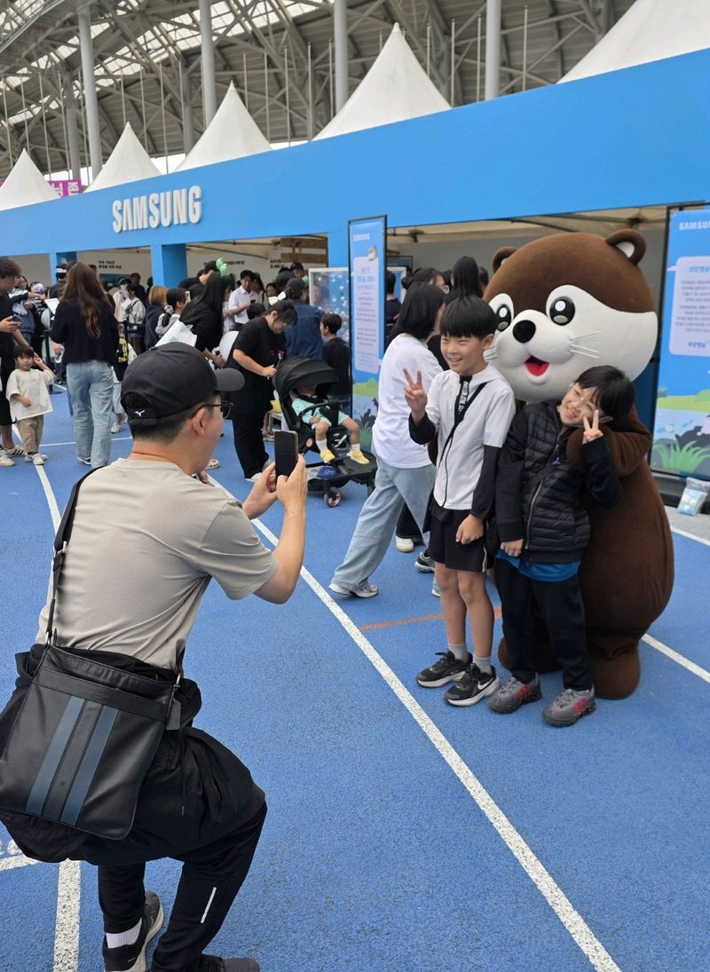 지난 3일 '2026 용인 사이버 과학축제'에 참여한 청소년들이 삼성전자 DS부문 친환경 캐릭터인 '달수'와 기념 촬영을 하고 있다. 삼성전자 제공