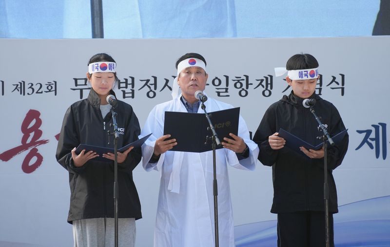임수진 중문청년회의소 특우회장과 학생 대표 2명이 3일 무오법정사 항일항쟁 기념식에서 결의문을 낭독하고 있다. 참석자들은 항일정신을 다음 세대가 기억하고 계승해 나가겠다는 뜻을 다졌다. 사진=제주특별자치도
