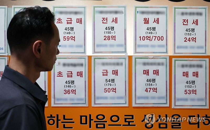 서울 강남구 한 부동산 중개업소에 붙은 매매·전세·월세 매물안내문을 한 시민이 보고 있다. 연합뉴스
