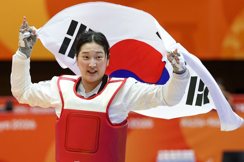 대한민국 송다빈이 3일 일본 도요하시 체육관에서 열린 2026 아이치·나고야 아시안게임 태권도 여자 +67㎏급 결승전에서 중국 무원저를 꺾고 금메달을 확정 짓자 태극기를 들고 기뻐하고 있다. 2026.10.3 ⓒ 뉴스1 안은나 기자