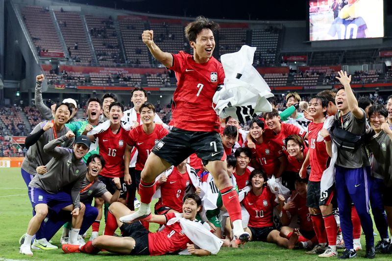 지난 3일 일본 아이치현 도요타 스타디움에서 열린 2026 아이치·나고야 아시안게임 남자 축구 결승전에서 한국팀이 일본을 꺾고 금메달을 차지한 뒤 기념촬영을 하던 중 엄지성(가운데)이 점프하며 기뻐하고 있다. 엄지성은 대회 득점왕과 도움왕을 차지했다. 연합뉴스