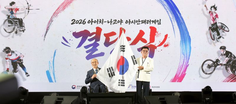 [서울=뉴시스] 6일 이천선수촌에서 열린 2026 아이치·나고야 장애인아시안게임 한국 선수단 결단식에서 정진완 회장이 박흥식 선수단장에게 단기를 전달하고 있다. (사진 = 대한장애인체육회 제공) *재판매 및 DB 금지