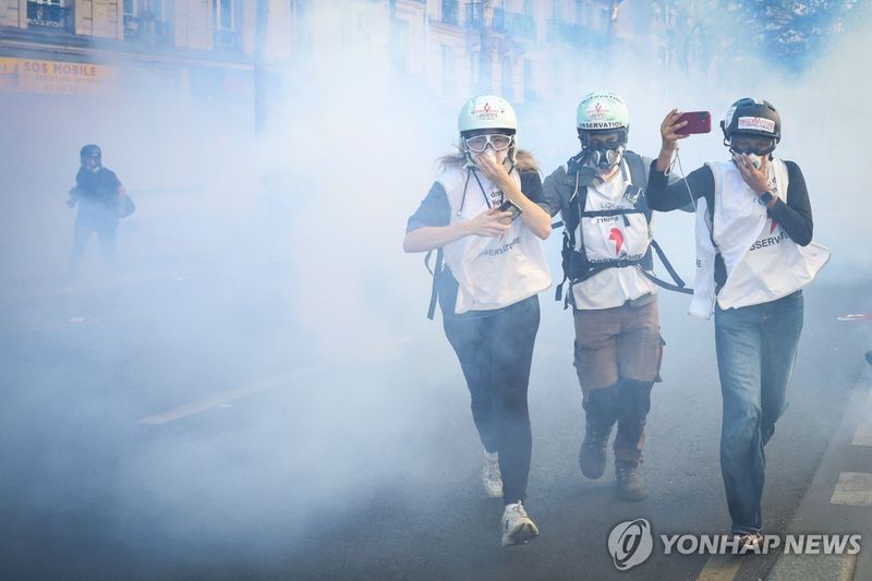 파리 학생 시위 현장에서 인권단체 옵서버들이 최루가스 사이로 뛰어가고 있다 (출처=연합뉴스)