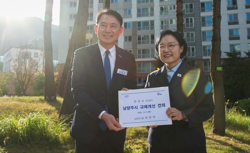 최현덕 남양주시장(왼쪽)이 지난 6일 위스테이 별내에서 한성숙 국무총리에게 규제 개선 건의서를 제출하고 있다. 남양주시 제공