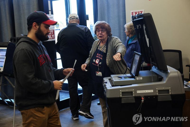 한 선거 관계자가 사전 투표가 시작되자 유권자를 안내하고 있는 모습 (출처=연합뉴스)