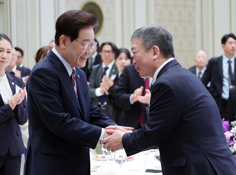 이재명 대통령이 7일 청와대 영빈관에서 열린 재일본대한민국민단 창단 80주년 기념 간담회에서 김이중 재일민단 중앙본부 단장과 인사를 하고 있다. 뉴시스