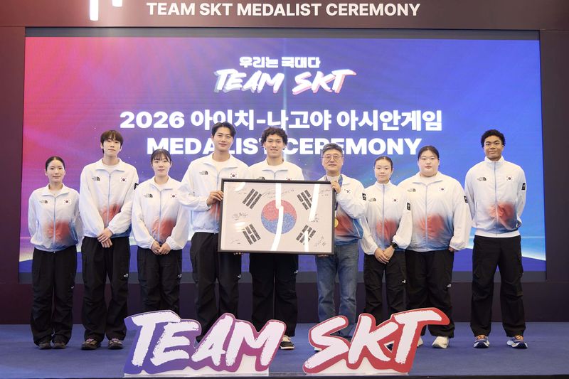 7일 서울 SKT타워에서 열린 '메달리스트 세리머니'에서 'Team SKT' 선수들의 사인을 담은 '국민응원 태극기' 액자를 정재헌 SK텔레콤 CEO에게 전달하고 있는 모습. 왼쪽부터 펜싱 송세라, 도경동, 전하영, 오상욱, 농구 에디 다니엘 선수, 정재헌 CEO, 근대5종 신수민, 역도 박혜정, 육상 나마디 조엘진 선수. SK텔레콤 제공