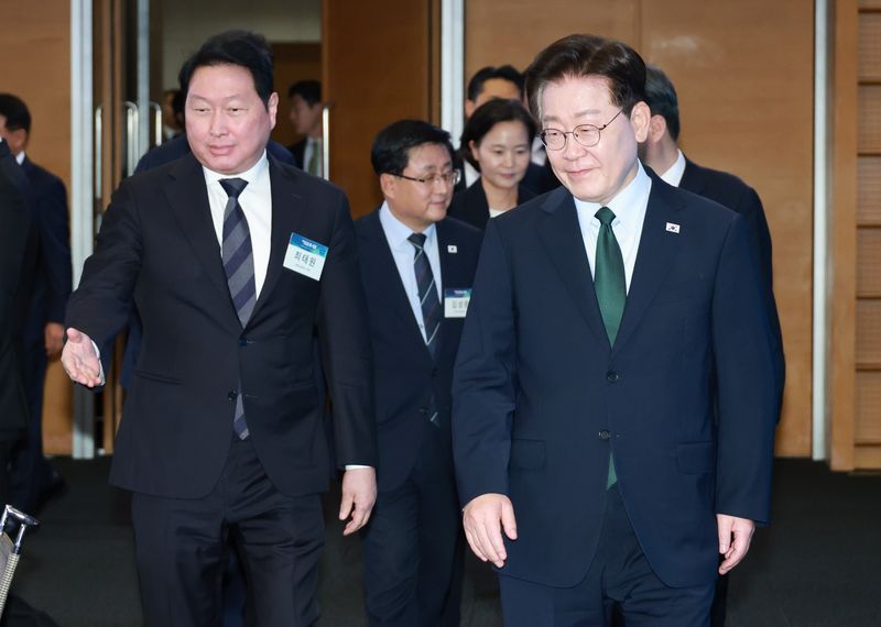 이재명 대통령이 7일 서울 한 회의장에서 열린 한국형 녹색 대전환(K-GX) 전략 국민보고회에 최태원 대한상공회의소 회장의 안내를 받으며 입장하고 있다. 연합뉴스
