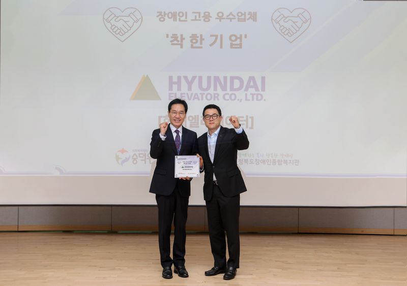 안지훈 현대엘리베이터 인사담당(오른쪽)과 이준호 사회복지법인 숭덕원 이사가 7일 충주 유네스코 국제무예센터에서 열린 ‘착한기업’ 현판 수여식을 마친 뒤 기념 촬영을 하고 있다. 현대엘리베이터 제공