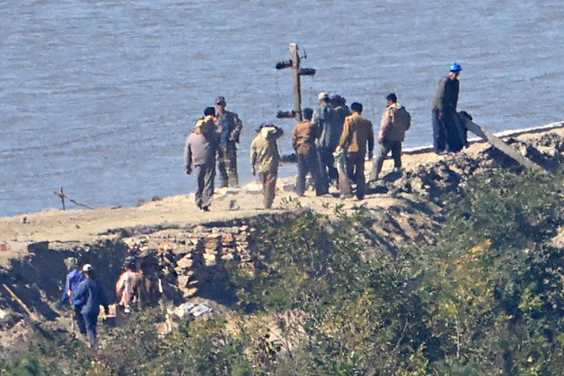 [김포=뉴시스] 김금보 기자 = 지난 7일 오후 경기 김포시 애기봉전망대에서 바라본 북한 개풍군 접경지에서 북한 주민들이 철책 및 전술도로 공사 석재를 옮기고 있다. 2026.10.07. kgb@newis.com