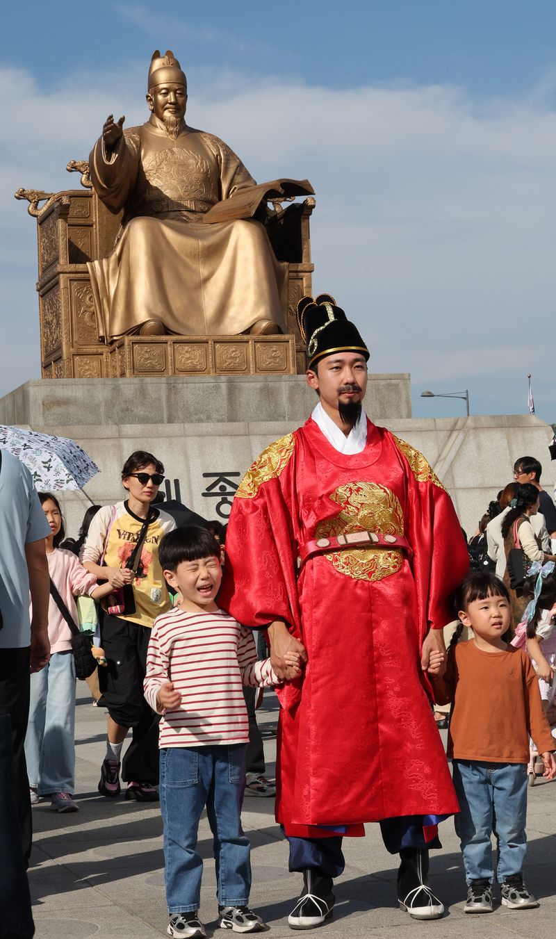 [서울=뉴시스] 박주성 기자 = 한글날 제정 100주년을 맞은 9일 서울 광화문광장 세종대왕 동상앞에서 세종대왕 복장을 한 연기자와 사진을 찍고 있다. 2026.10.09. park7691@newsis.com