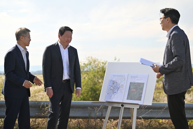 [전남광주=뉴시스] 이영주 기자 = 최태원(가운데) SK그룹 회장과 민형배(왼쪽) 전남광주통합특별시장이 9일 오후 전남광주 서구 벽진동 주변 광주군공항 '호남 반도체 클러스터' 조성 예정지에서 반도체팹 조성 브리핑을 듣고 있다. 2026.10.09. leeyj2578@newsis.com