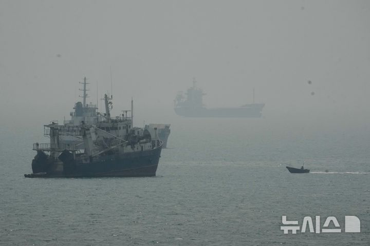 [반다르아바스=AP/뉴시스] 이란 이슬람혁명수비대(IRGC)는 10일(현지 시간) 이란이 지정하지 않은 항로로 호르무즈 해협을 통과하려던 대형 유조선 한 척이 기뢰외 충돌해 폭발했다고 주장했다. 사진은 지난달 7일 이란 반다르아바스 인근 호르무즈 해협에서 닻을 내린 상선들 사이로 모터보트 한 대가 지나가는 모습. 2026.10.11.