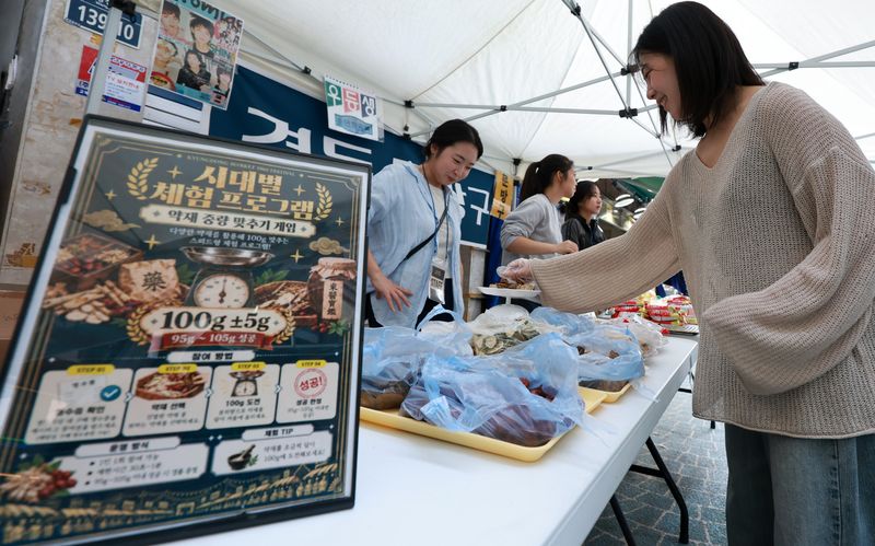 [서울=뉴시스] 이영환 기자 = 11일 오후 서울 동대문구 경동시장에서 열린 '경동시장 1960 페스티벌'을 찾은 시민이 약재 중량 맞추기 게임을 하고 있다. 2026.10.11. 20hwan@newsis.com