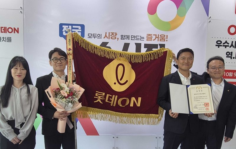 지난 9일 충남 공주시 아트센터 고마에서 열린 '2026년 전통시장 및 상점가 활성화 유공 포상'에서 김장훈 롯데온 상무(오른쪽 두번째)가 임직원과 함께 대통령 표창 기념 사진을 촬영하고 있다. 롯데온 제공