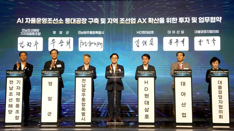 민형배 전남광주통합특별시장(광주특별시장·왼쪽에서 세 번째)과 김정관 산업통상부 장관(네 번째)이 12일 영암 호텔현대 바이 라한에서 열린 'AI 자율 운영 조선소 투자·업무 협약식'에서 영암군·HD현대삼호·대아산업·대불경영자협의회·전남조선해양기자재협동조합 관계자들과 기념촬영을 하고 있다. 광주특별시 제공