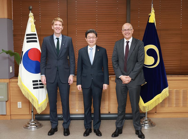이억원 금융위원장이(가운데)이 12일 오후 서울 종로구 정부서울청사에서 영국 스탠다드차타드그룹(SC그룹) 마누스 코스텔로 최고재무책임자(CFO), 제이슨 포레스터 최고위험책임자(CRO)와 기념촬영을 하고 있다. 금융위원회 제공