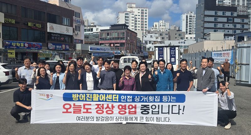 천기옥 울산 동구청장과 동구청 직원들이 12일 방어진활어센터 인근에서 이 지역 상권 활성화를 위한 캠페인을 벌이고 있다. 동구는 이번 캠페인의 일환으로 이날 해양환경국을 시작으로 부서별 단체 점심 식사 릴레이에 돌입했다. 울산 동구 제공