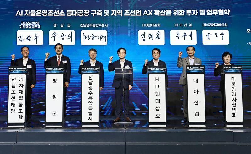 김정관 산업통상부 장관(가운데)이 12일 전남광주 영암에서 민형배 전남광주통합특별시장(왼쪽 세번째), 김재을 HD현대삼호 사장(왼쪽 다섯번째) 등과 'AI 조선소 등대공장' 구축 및 지역 조선업 AX 확산을 위한 업무협약을 맺은 뒤 기념촬영을 하고 있다. 산업통상부 제공