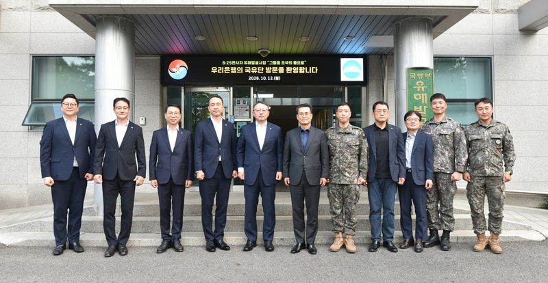 지난 12일 정진완 우리은행장(왼쪽 다섯번째부터), 전병희 국방부 유해발굴감식단장과 양 기관 주요 관계자들이 서울 동작구 국립서울현충원 내 국방부 유해발굴감식단에서 기념촬영을 하고 있다. 우리은행 제공