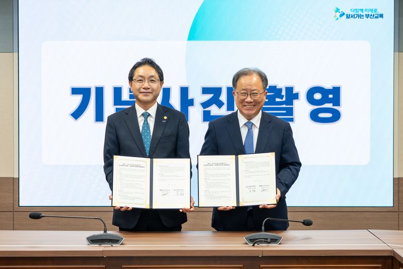 부산광역시약사회 변정석 회장(왼쪽)과 김석준 부산시교육감이 업무협약서를 들고 포즈를 취하고 있다. 부산시교육청 제공