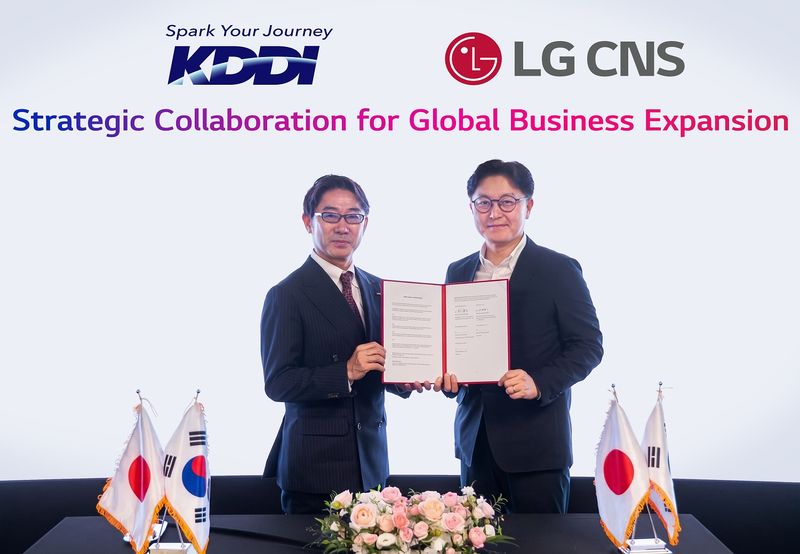 LG CNS 통신/유통/서비스사업부장 박상균 전무(오른쪽)와 KDDI 비즈니스그로스 사업본부 마츠우라 켄타로 부사업본부장이 업무협약식에서 사진촬영 하는 모습.LG CNS 제공