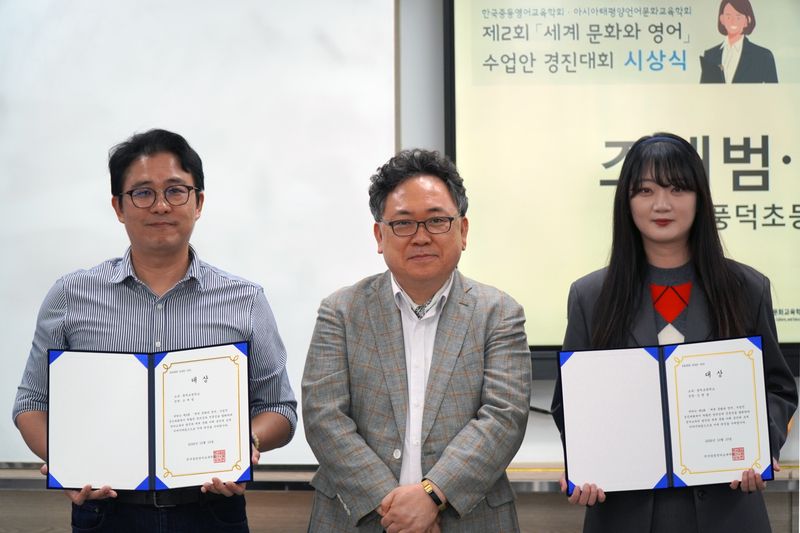 비상교육이 협력사로 참여한 '제2회 세계 문화와 영어 수업안 경진대회' 시상식에서 대상을 수상한 조재범 교사(왼쪽)와 김햇살 교사(오른쪽)가 정채관 한국중등영어교육학회 회장(가운데)과 기념 촬영을 하고 있다. 비상교육 제공