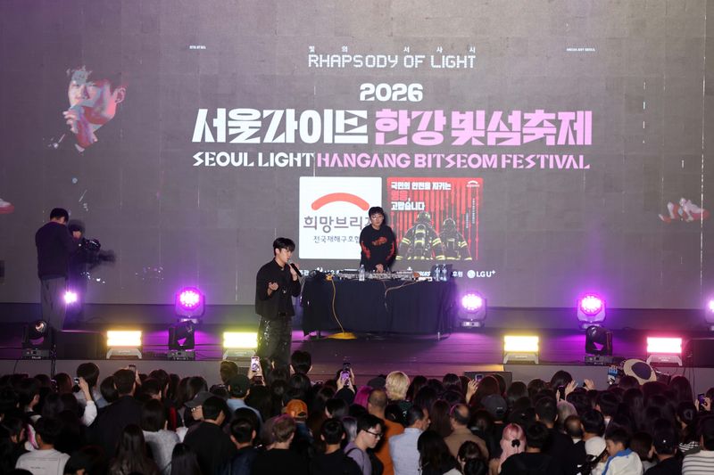 희망브리지 희망대사인 래퍼 쿠기가 지난 10일 서울 용산구 노들섬에서 열린 '2026 서울라이트 한강 빛섬축제' 무대에서 소방관 응원 캠페인 참여를 독려하고 있다. 희망브리지 제공