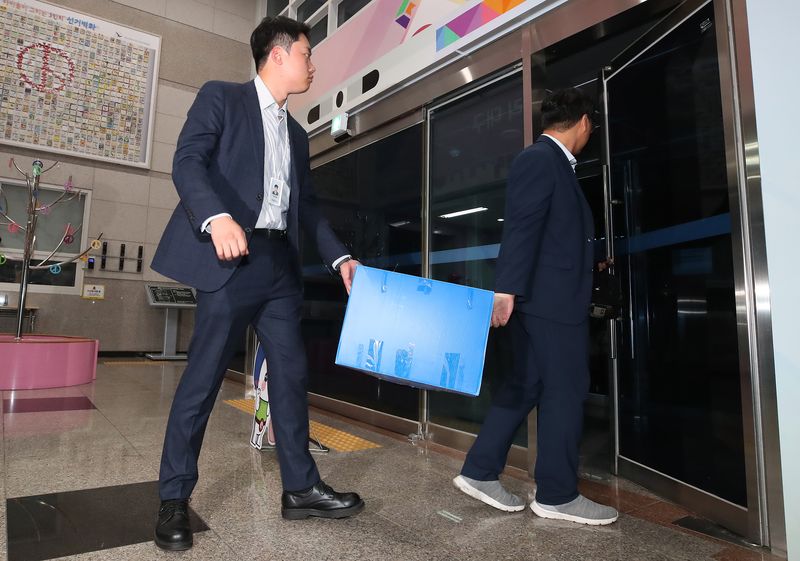 6·3 지방선거 투표용지 부족 사태를 수사하는 선관위 특검팀이 지난달 17일 대구시 선거관리위원회에 대한 압수수색을 마친 뒤 압수 물품을 챙겨 청사를 나서고 있다. 뉴스1
