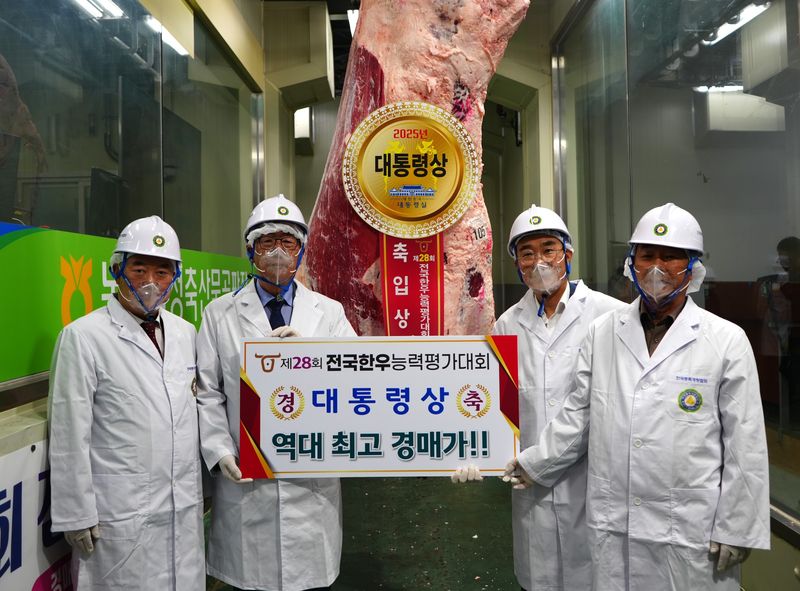 지난해 전국한우능력평가대회에서 대통령상을 수상한 한우의 피켓을 들고 관계자들이 기념촬영을 하고 있다. 한국종축개량협회 제공