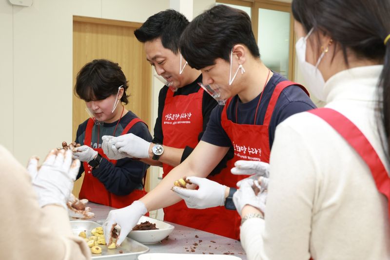 지난 14일 서울 영등포구청 별관 내 희망수라간에서 'TEAM 나눔런치'에 참여한 롯데홈쇼핑 임직원들이 영등포 지역 독거 어르신에게 전달할 공주 밤 찹쌀떡을 만들고 있다. 롯데홈쇼핑 제공