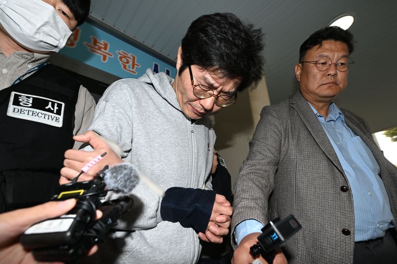 [전남광주=뉴시스] 이영주 기자 = 강도살인 혐의를 받는 박용수(53·가운데)가 16일 오전 전남광주 동구 동부경찰서에서 공소청으로 송치되고 있다. 박용수는 채무를 이유로 지인 60대 A씨 부부를 살해하고 현금카드를 빼앗아 달아난 혐의를 받고있다. 2026.10.15. leeyj2578@newsis.com