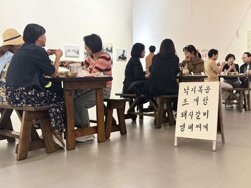 롯데뮤지엄 '미드위크 뮤지엄' 참가자들이 이강소의 설치작 '소멸'에서 술과 음식을 즐기며 이야기를 나누고 있다. 롯데문화재단 제공