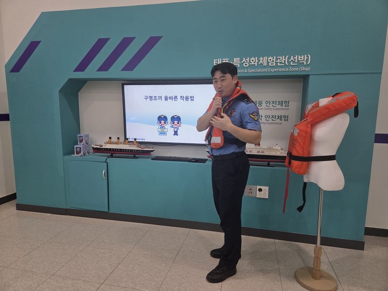 제주안전체험관에서 현직 해양경찰관이 구명조끼를 착용하고 올바른 착용법을 설명하고 있다. 제주안전체험관은 제주지방해양경찰청과 협력해 매월 셋째 주 토요일 선박 특별 안전체험을 운영하며 해상 재난 대응교육을 강화한다. 사진=제주안전체험관