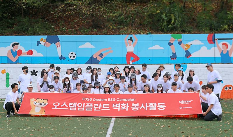지난 15일 서울 신월동 서울SOS어린이마을 환경개선 봉사활동에 참가한 오스템임플란트 임직원들이 기념사진을 찍고 있다. 오스템임플란트 제공