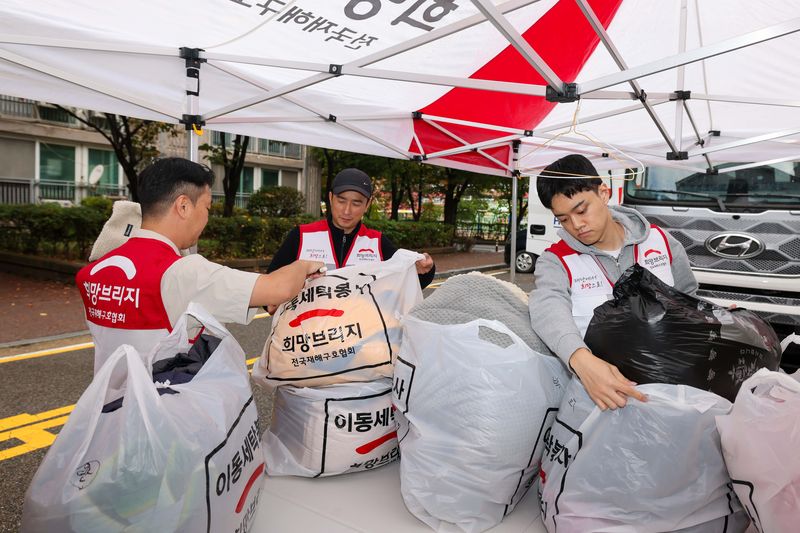 희망브리지 전국재해구호협회 직원과 봉사자들이 경기 고양시 문촌마을 영구임대아파트에서 재난취약계층의 세탁물을 수거하고 있다. 희망브리지 제공