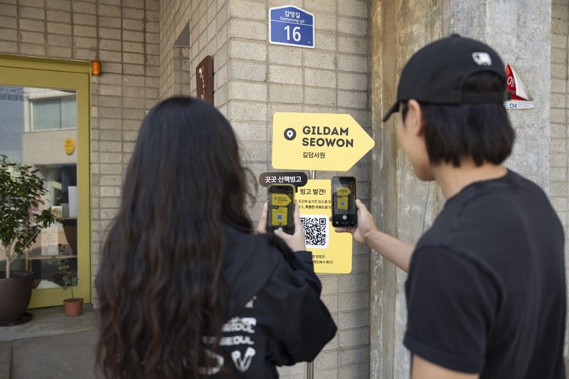 지난 16일 충남 공주 제민천 인근에서 '곳곳 공주' 산책빙고 참여자가 QR코드를 스캔하고 있다. 카카오 제공