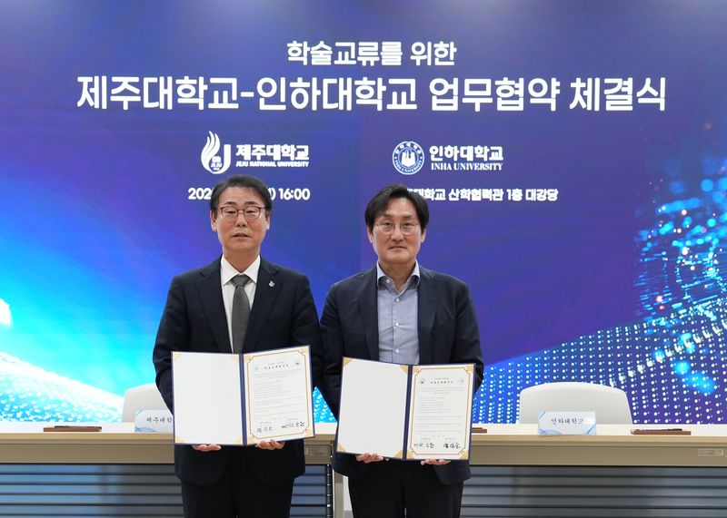 지난 19일 제주대학교 산학협력관에서 양덕순 제주대 총장(왼쪽)과 백성현 인하대 교학부총장이 학술·학점교류 협정을 체결하고 협약서를 들어 보이고 있다. 양 대학은 교육·연구 자원 공유와 학생 교류를 추진하고, AI·우주항공 분야의 초광역 협력 방안도 논의했다. 사진=제주대학교