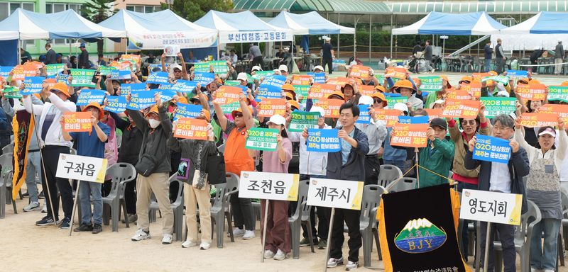 지난 18일 부산광역시 영도구 영도초등학교에서 열린 부산제주특별자치도민 가족한마당 축제에서 참석자들이 2028년 G20 정상회의 제주 유치를 기원하는 손팻말을 들어 보이고 있다. 정상회의 유치 경쟁에 나선 부산에서 제주 출향도민들이 고향 개최를 지지하는 결의행사를 열었다. 사진=부산제주특별자치도민회