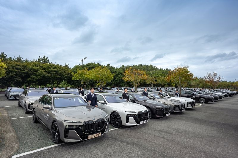 BMW 코리아 관계자들이 'BMW 레이디스 챔피언십 2026' 의전 차량 앞에서 기념촬영을 하고 있다. BMW 코리아 제공