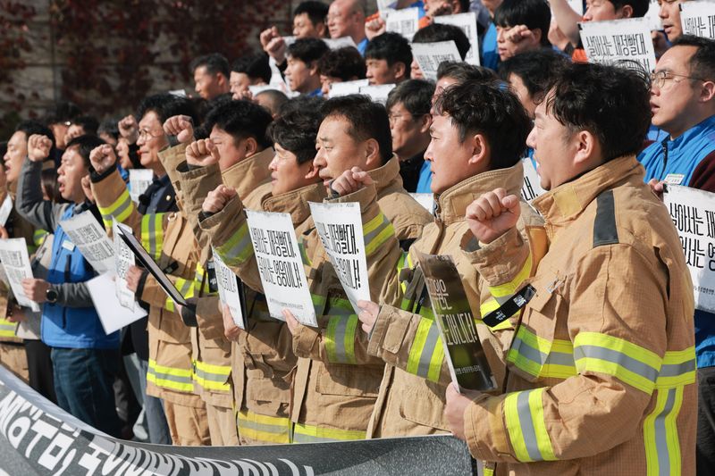 21일 국회 본청 앞 계단에서 대한민국공무원노동조합총연맹 소방공무원노조와 송영길 더불어민주당 의원이 연 '소방공무원 명예회복괴 소방조직 정상화 촉구 기자회견'에서 소방관들이 임을 위한 행진곡을 부르고 있다. 연합뉴스