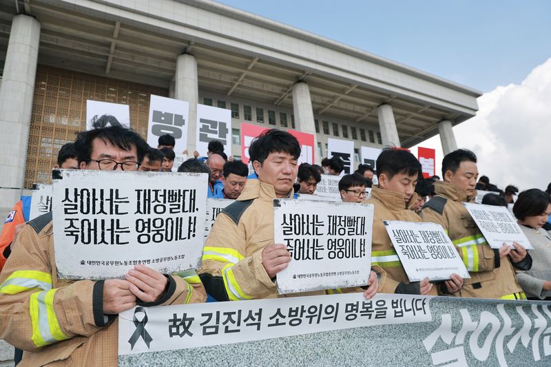 21일 국회 본청 앞 계단에서 대한민국공무원노동조합총연맹 소방공무원노조와 더불어민주당 송영길 의원이 연 '소방공무원 명예회복과 소방조직 정상화 촉구 기자회견'에서 소방관들이 부천 공장 화재 진압 중 순직한 고 김진석 소방위를 추모하며 묵념하고 있다. 연합뉴스