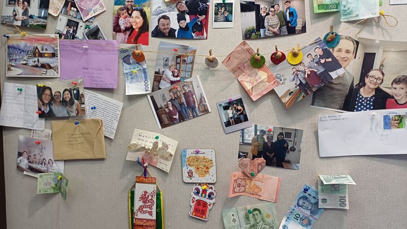 메스티아 숙소 벽면에 걸린 관광객의 사진과 각 나라의 지폐.