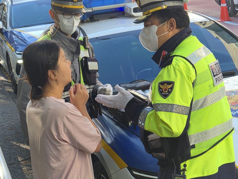 경찰이 22일 서울 송파구 신가초등학교 앞 어린이보호구역(스쿨존)에서 음주운전 단속에 적발된 운전자 A씨에게 단속 상황을 설명하고 있다. 사진=이동혁 기자