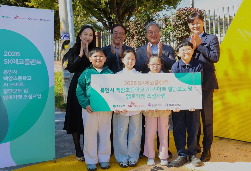 박찬경 초록우산 사회공헌사업센터장, 장한규 SK에코플랜트 부사장, 황준기 용인특례시 제2부시장, 이경호 백암초 교장(두번째줄 왼쪽부터) 등 관계자들이 최근 용인 백암초에서 열린 '인공지능(AI) 스마트 횡단보도 및 옐로카펫 조성사업' 준공식에서 기념촬영하고 있다. SK에코플랜트 제공
