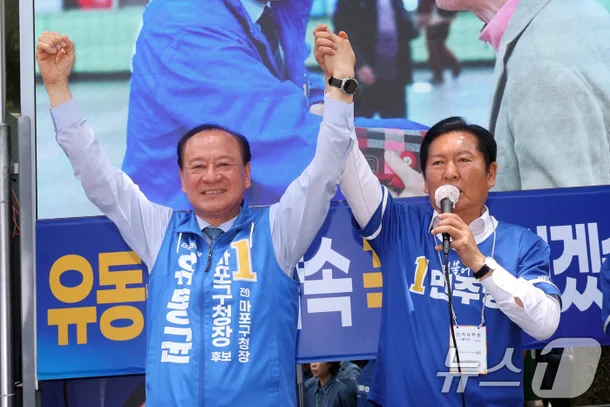지난 6월 유동균 마포구청장과 정청래 국회의원(마포구 을)이 서울 마포구 망원역 앞에서 선거운동을 하고 있다. 뉴스1