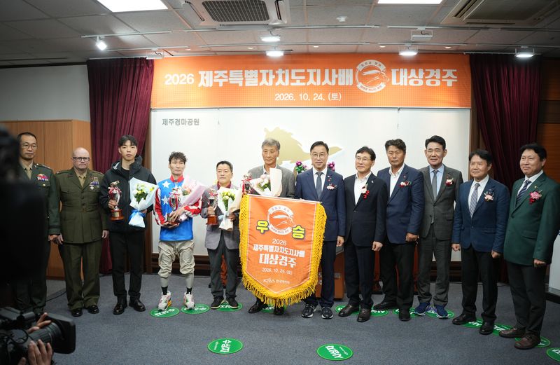 24일 렛츠런파크 제주에서 열린 '2026 제주특별자치도지사배 대상경주' 시상식에서 위성곤 제주도지사와 경주 수상 관계자, 주요 참석자들이 우승기와 트로피를 들고 기념촬영을 하고 있다. 이날 대상경주에는 제주마 10마리가 출전했다. 사진=제주특별자치도